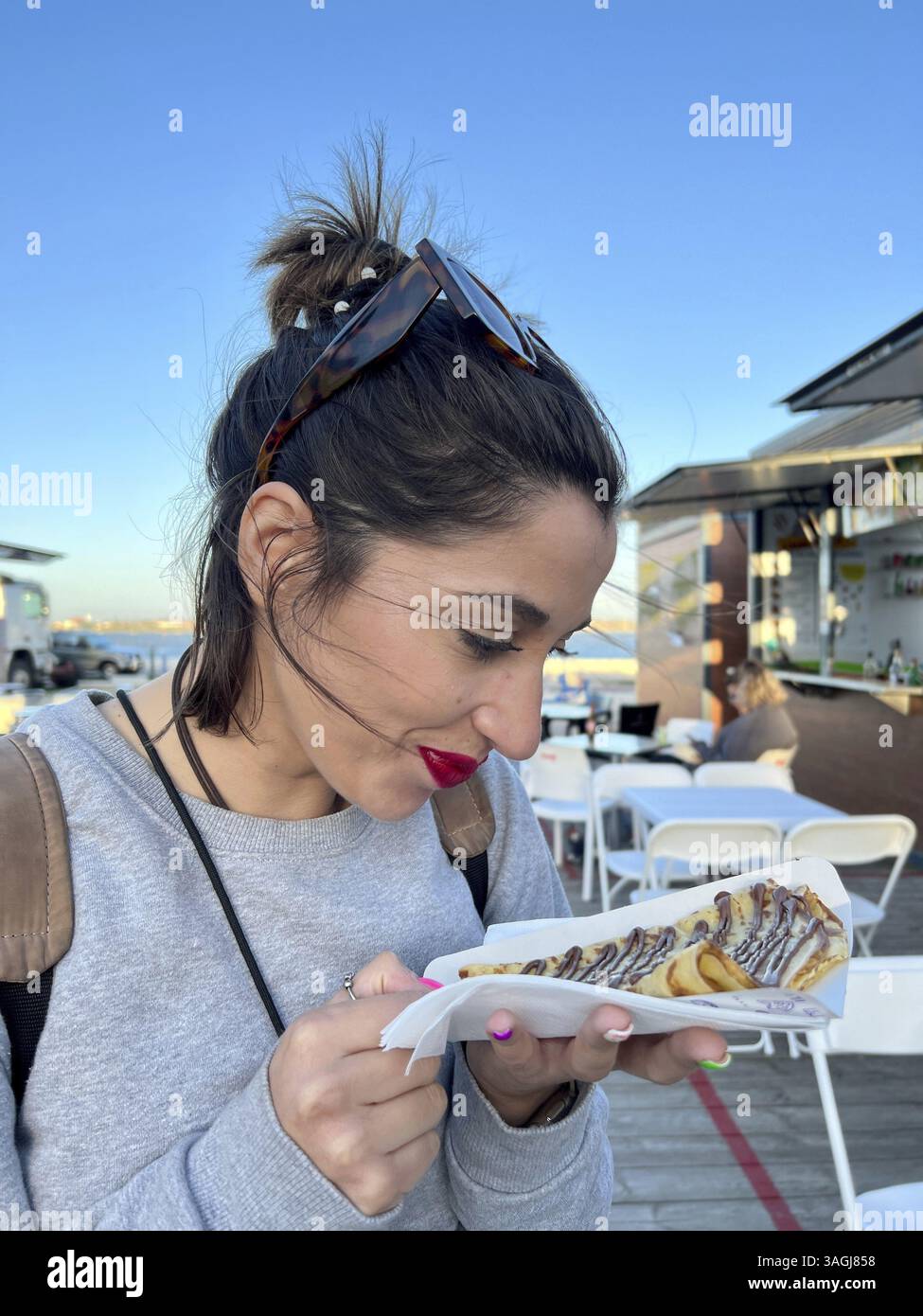 Fille touriste mangeant de la crêpe française dans la rue. Gros plan d'une femme mangeant des crêpes avec du nutella en descendant la rue Banque D'Images