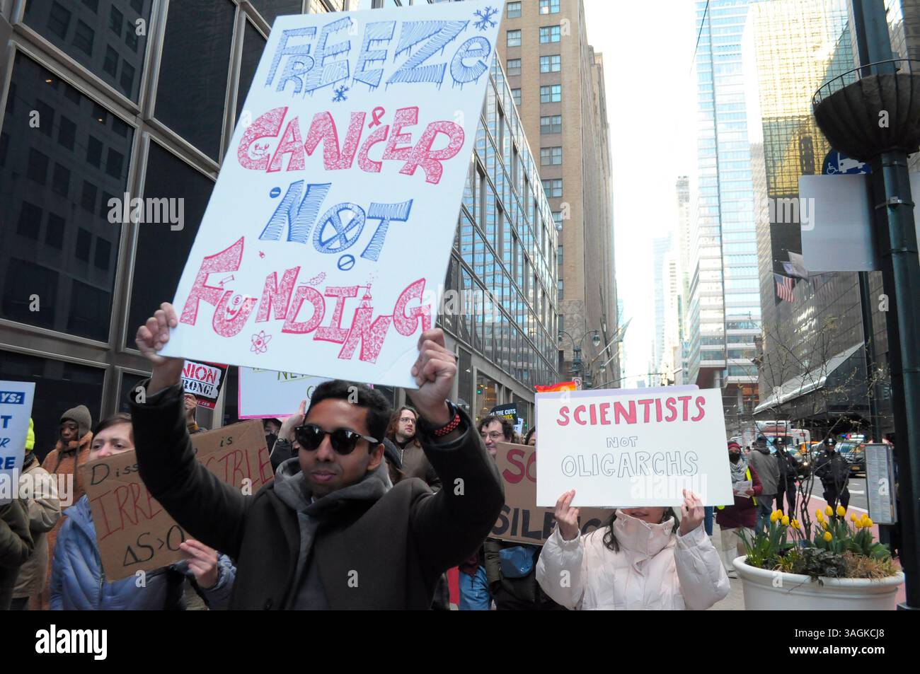 Les manifestants défilent avec des pancartes pendant le rassemblement. Des manifestants à Manhattan ont protesté contre l’administration Trump pour avoir coupé les fonds destinés aux soins médicaux et à la recherche. Les manifestants ont également critiqué Elon Musk, le chef du département de l'efficacité du gouvernement, DOGE, pour avoir licencié des employés fédéraux et coupé les services fédéraux. Selon les manifestants, les coupes fédérales dans les fonds qui vont aux Instituts nationaux de la santé nuisent à la recherche médicale sur des maladies comme le cancer, la maladie d'Alzheimer et le diabète. Les manifestants ont également déclaré que les coupes budgétaires nuiraient à l'éducation des étudiants universitaires qui le souhaitaient Banque D'Images