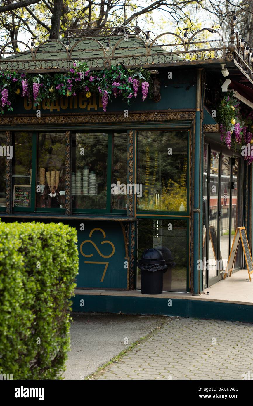Kiosque vert décoratif avec du fer forgé et des fleurs suspendues dans un parc public à Sofia, Bulgarie, au printemps. Banque D'Images