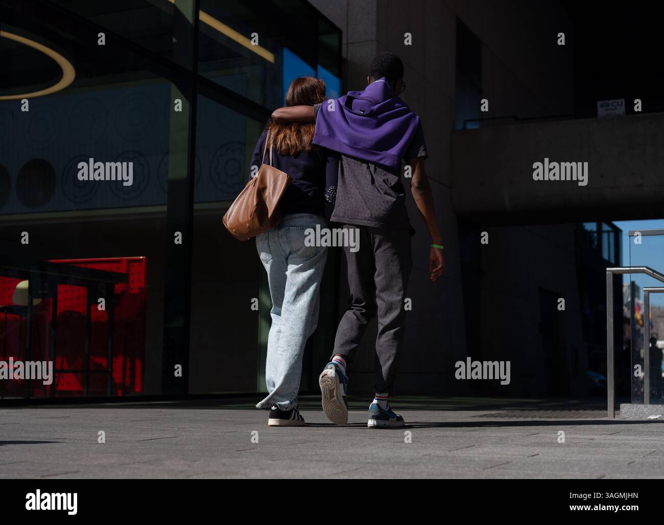 Un jeune couple marche les bras autour de l'autre dans la ville de Dublin, en Irlande. Banque D'Images