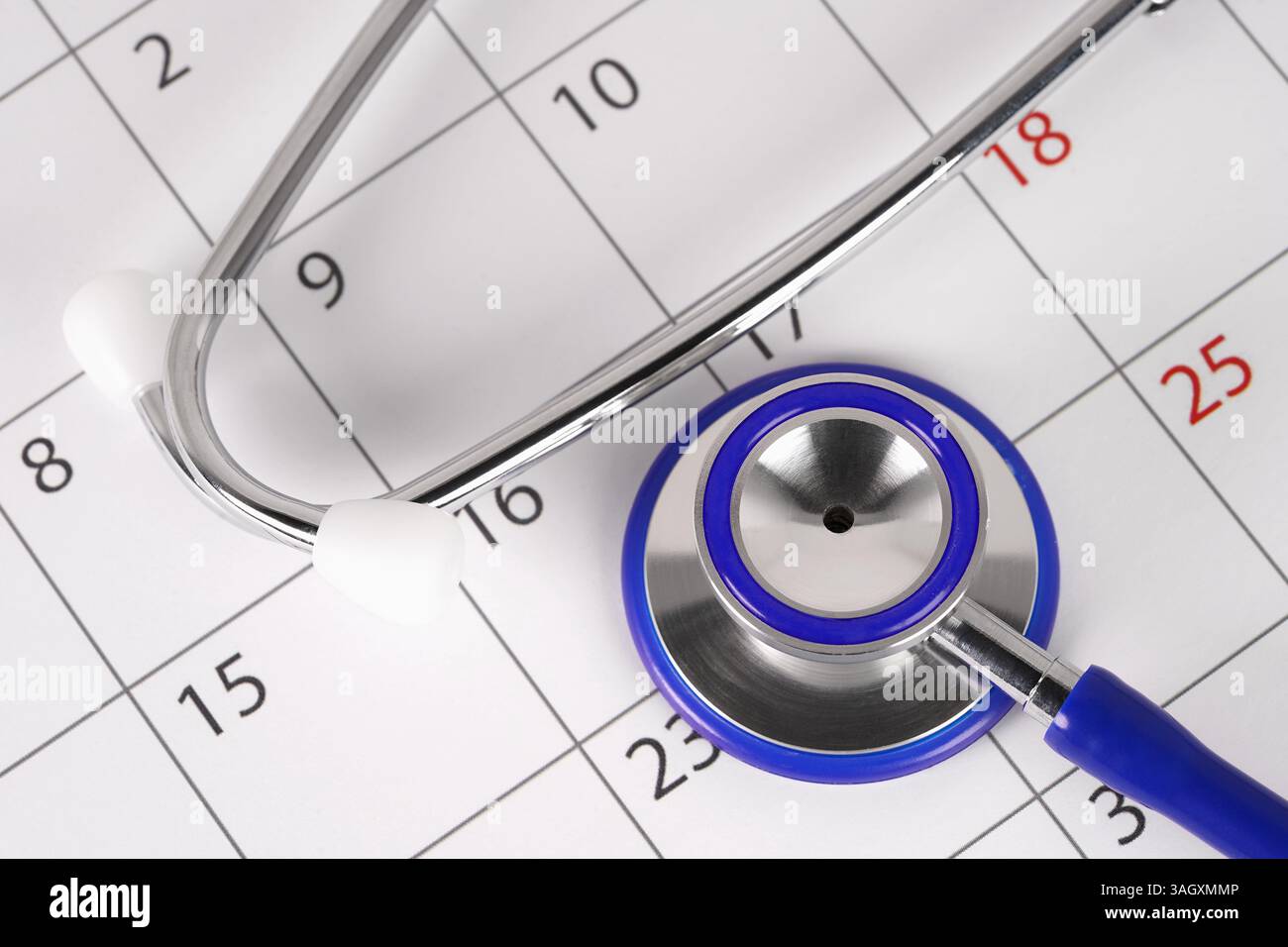 Vue rapprochée d'un stéthoscope sur une page de calendrier, concept médical de planification d'un rendez-vous chez le médecin et de bilans médicaux. Banque D'Images