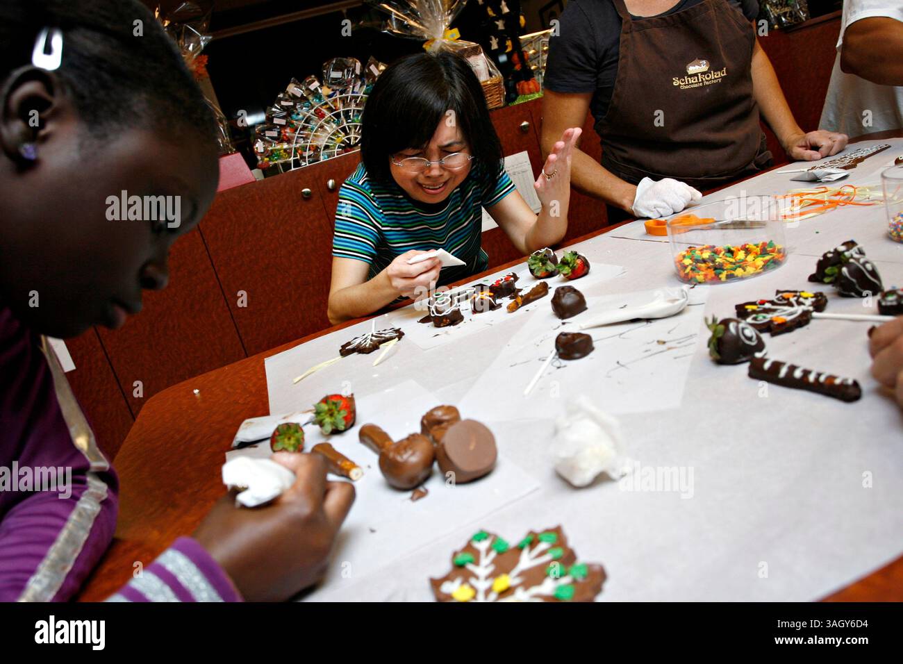 MELISSA LYTTLE | Times. SP 313564 LYTT NAYCHOCOLATE 1 (10/20/2009 ST. PETERSBURG) Phuong Tran, originaire du Vietnam, laisse son perfectionnisme tirer le meilleur parti d'elle tout en décorant des morceaux de chocolat qu'elle a faits lors d'une excursion amusante à la chocolaterie Schakolad avec sa classe ESOL du Tomlinson Adult Center. L'instructeur Mike Cantore s'est associé avec des entreprises locales de Petersburg, afin d'offrir un environnement d'apprentissage pratique pour ses étudiants adultes de niveau intermédiaire de haut niveau pour pratiquer leurs compétences linguistiques en anglais dans des environnements réels. Cette activité particulière a travaillé sur Banque D'Images