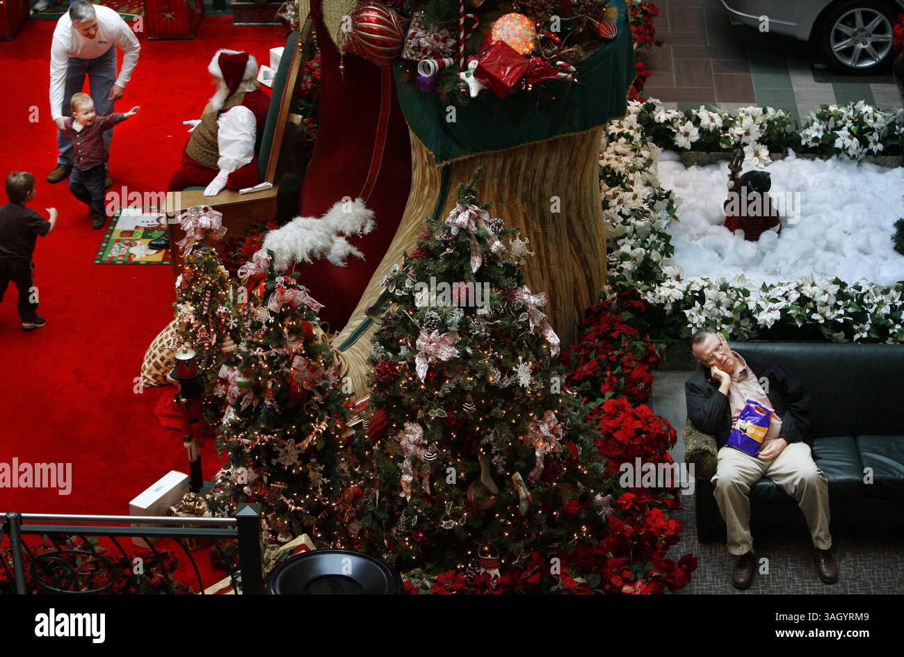 Dec. 23, 2009 - Memphis, TN, USA - mer, 23 déc 09 (asmallnap1) photo par Alan Spearman. Le Père Noël divertit les jeunes au Wolfchase Mall mercredi après-midi alors que Russ Cox (cq) de Humboldt, TN obtient un peu fermé les yeux en attendant sa femme Betty pour faire des achats de Noël. Ils faisaient les courses depuis 10h30 ce matin. (Crédit image : © The commercial Appeal/ZUMApress.com) Banque D'Images