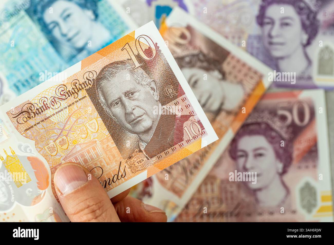 Nouveau billet représentant un portrait du roi Charles III, émis pour la première fois en juin 2024 par la Banque d'Angleterre, Royaume-Uni. En arrière-plan, les billets de banque plus anciens avec le i. Banque D'Images