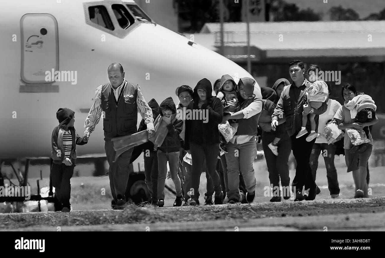 22 juillet 2014 - Guatemala City, Guatemala - des travailleurs du gouvernement guatémaltèque, vêtus de gilets bleus, escortent les mères avec leurs enfants de l'avion après avoir été expulsés des États-Unis trois avions, deux pleins d'adultes et un troisième plein d'adultes, dont 7 mères et 13 enfants, sont arrivés du côté de l'armée de l'air du Guatemala de l'aéroport de la Aurora à Guatemala City, au Guatemala. (Crédit image : © San Antonio Express-News/ZUMA Wire) Banque D'Images