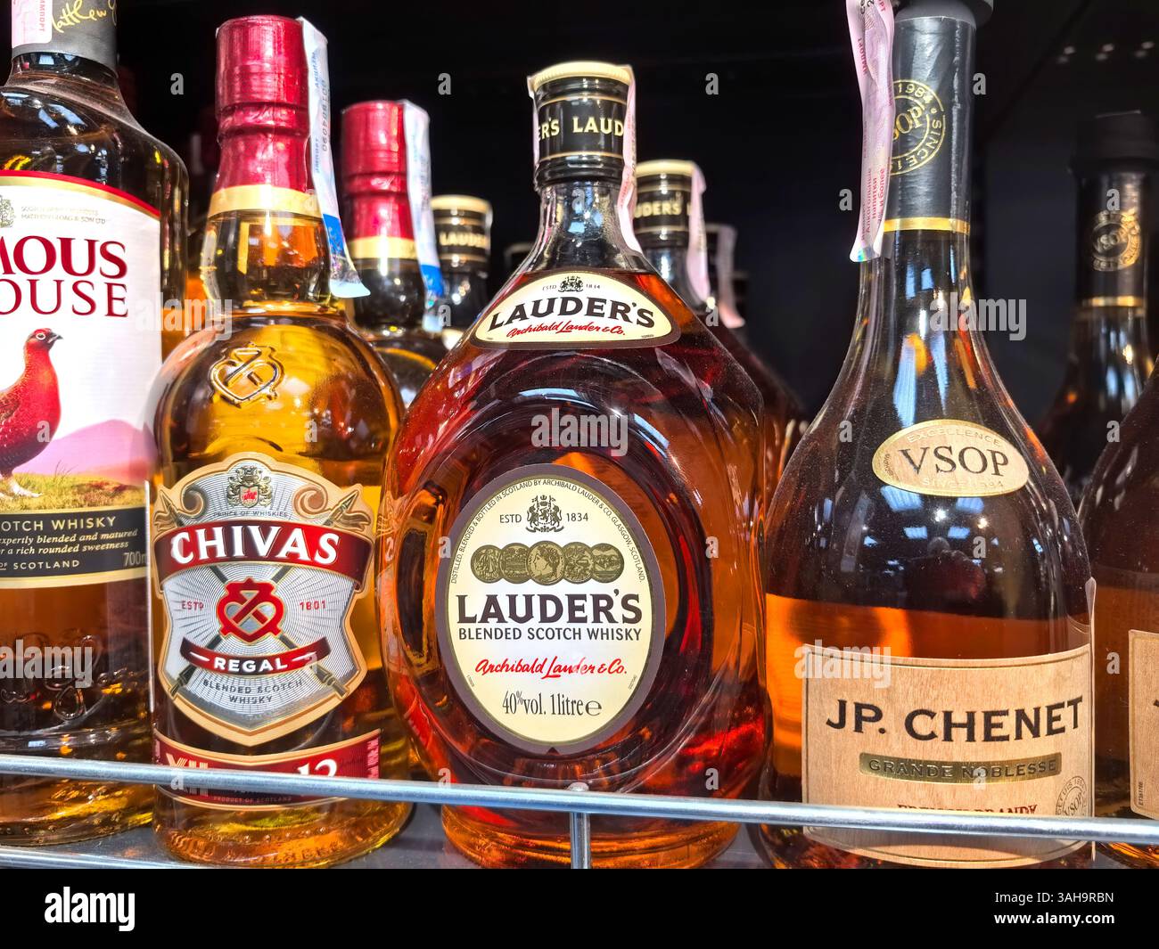 Bobruisk, Biélorussie - 10 mars 2025 : étagère d'un magasin d'alcools très éclairée regorgeant de bouteilles assorties de whisky et d'eau-de-vie. Chaque étiquette raconte une histoire de cr Banque D'Images