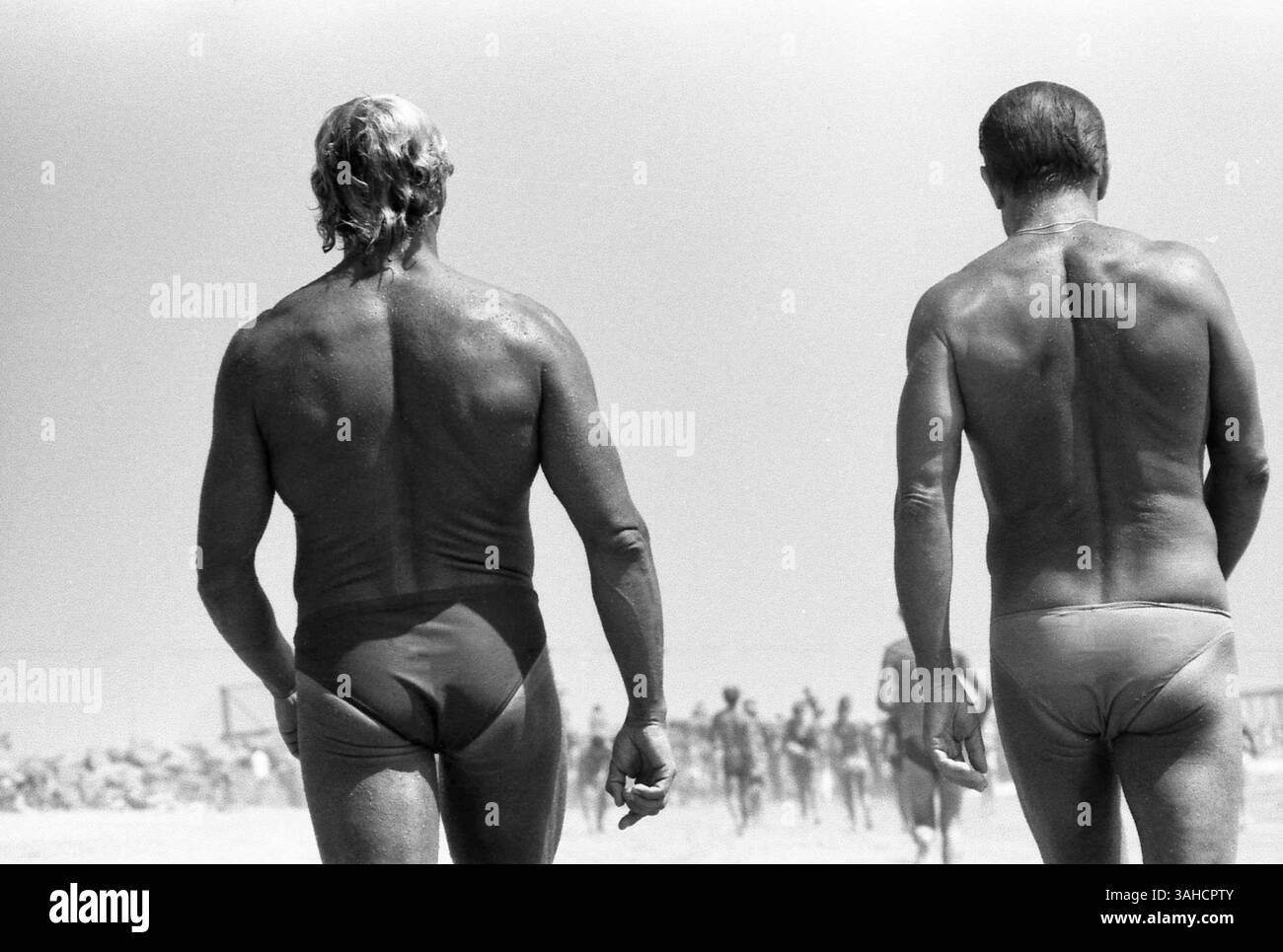 Venice Beach, Los Angeles, CA, États-Unis, approx. 1985. Hommes marchant sur la plage portant un slip speedo. Banque D'Images