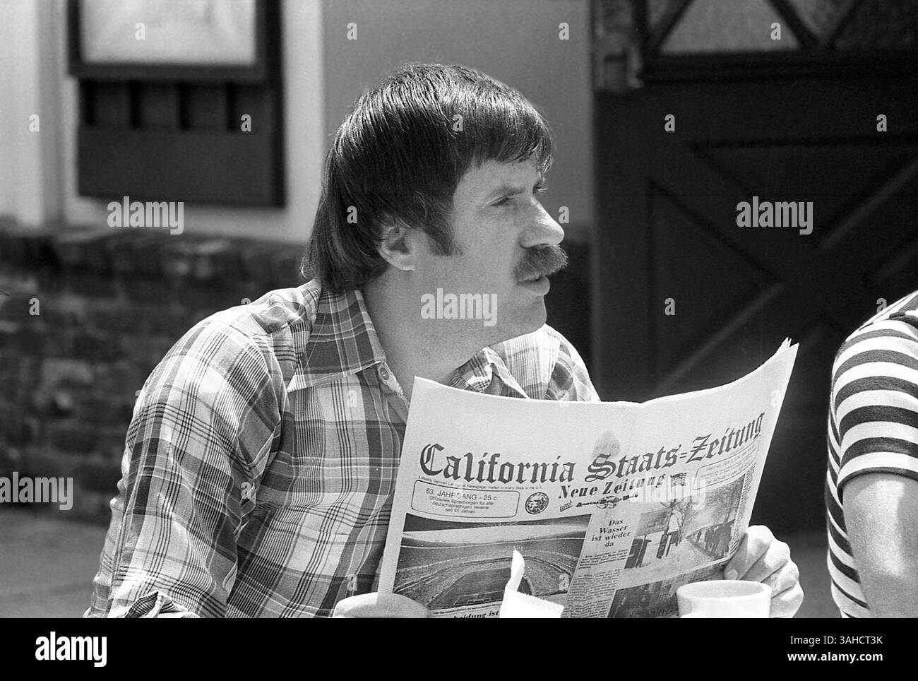Los Angeles, CA, États-Unis, approx. 1985. Homme lisant le journal en langue allemande 'California-Staats Zeitung'. Banque D'Images