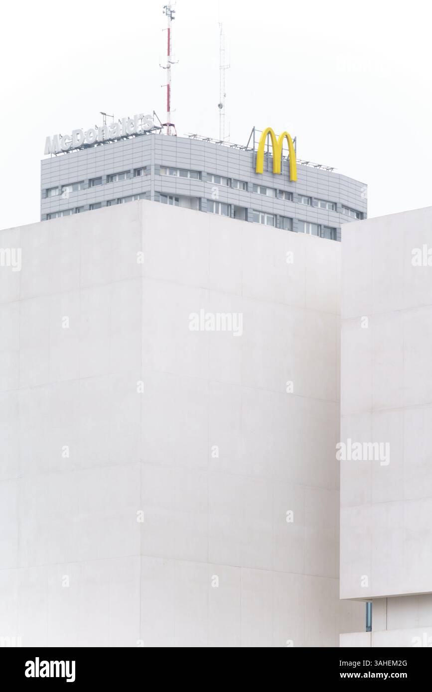 Immeuble d'appartements dans le centre-ville de Varsovie avec le logo McDonald's sur le dessus obscurci par le musée d'art contemporain en construction. Banque D'Images