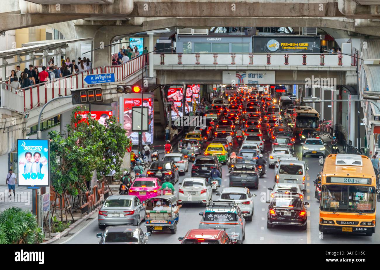 Thaïlande-03 juillet 2024 : le trafic routier conjesté l'après-midi se déplace lentement, comme les navetteurs marchent au-dessus de la circulation des véhicules, sur des sentiers élevés. Banque D'Images