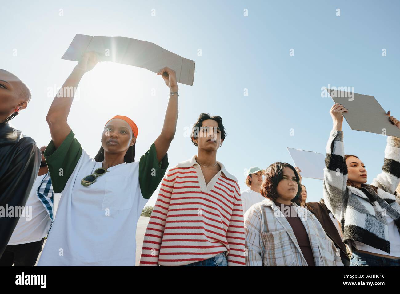 Un groupe d'individus participe à une manifestation pacifique, prônant la justice sociale et l'égalité. Ils tiennent des signes et font preuve de solidarité. Banque D'Images
