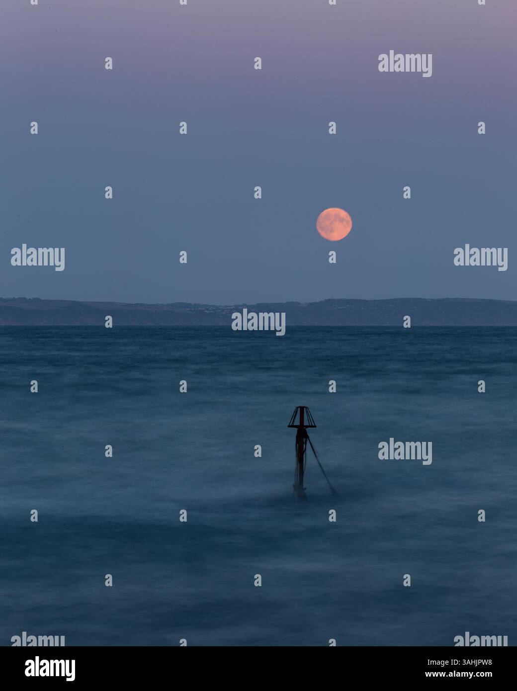 Super Moon se levant au-dessus des falaises de Whitsand Bay Cornwall pris de Looe, y compris Little mine à l'entrée de Looe Harbour Banque D'Images