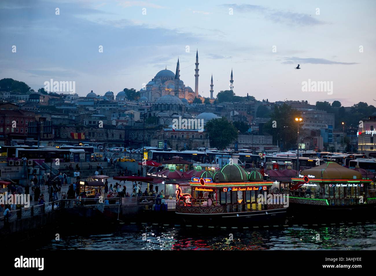 Vue en soirée sur le front de mer animé d'Istanbul avec des lumières vives et la mosquée Suleymaniye en arrière-plan. Istanbul, Turquie Banque D'Images