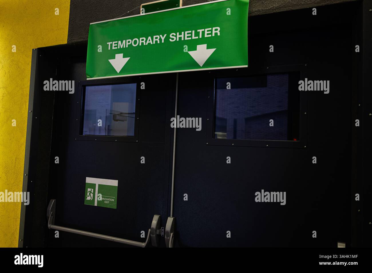 Porte de secours avec un panneau vert pour un accès immédiat à un abri temporaire Banque D'Images