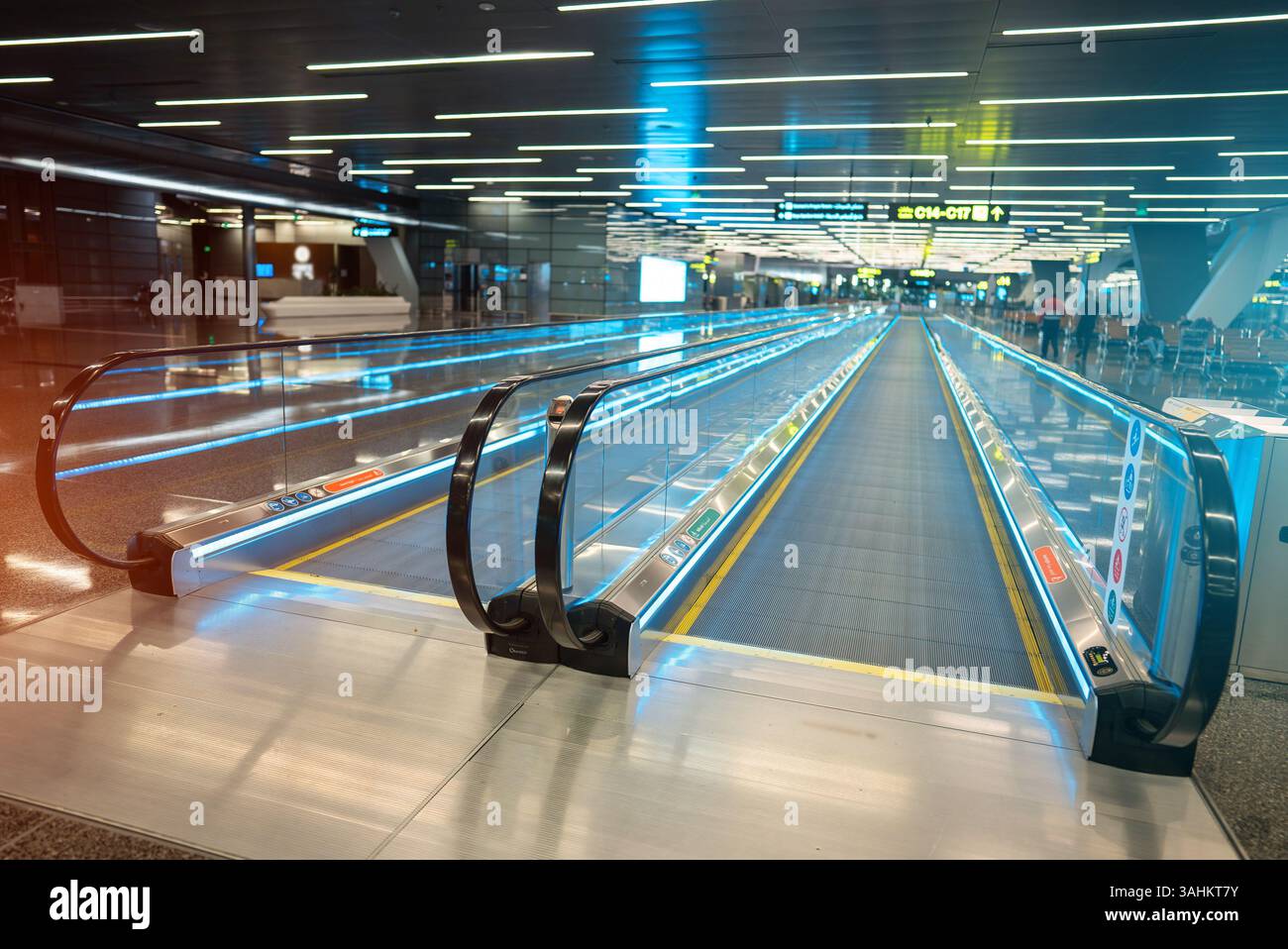 Passerelle mobile d'aéroport moderne avec garde-corps en verre lumineux, système de convoyeur de terminal efficace avec design bleu élégant. Photo de haute qualité Banque D'Images