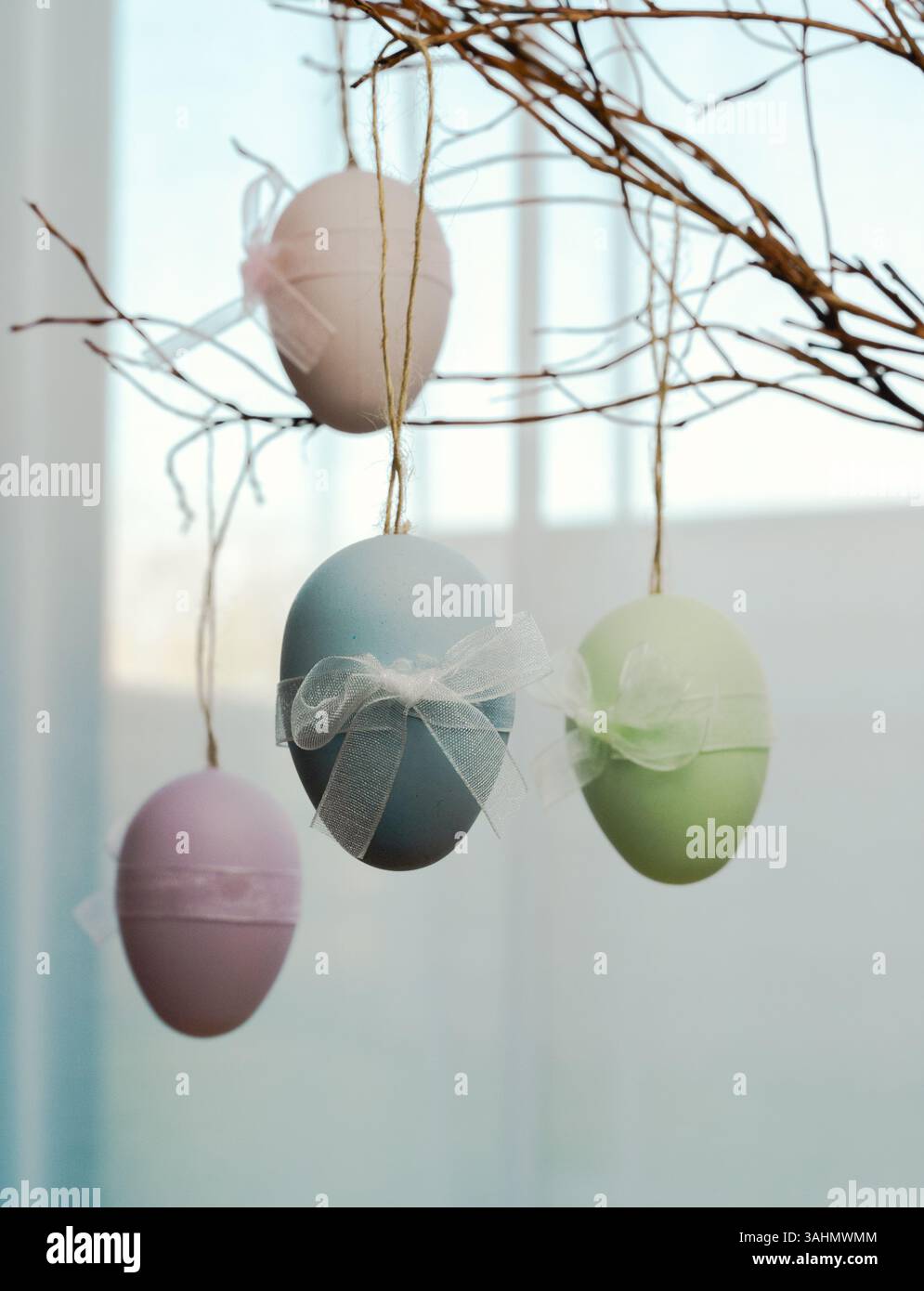 Les œufs de Pâques colorés suspendus à des branches créent une décoration printanière parfaite pour chaque célébration joyeuse Banque D'Images