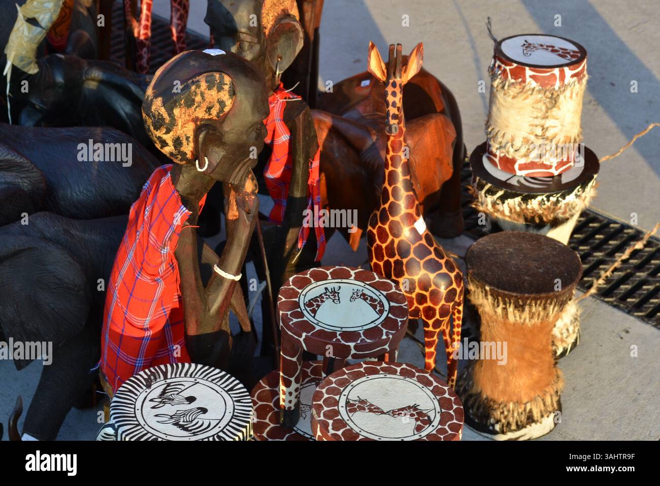 Exposition d'art africain à vendre à l'extérieur du pavillon du cluster de café de l'EXPO Milano 2015. De nombreux tambours en cuir et statues de femme et d'animal en bois Banque D'Images