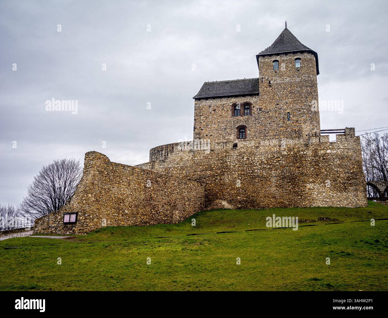 Un très grand château de pierre est majestueusement assis au sommet d'une colline herbeuse à Bedzin, en Pologne Banque D'Images
