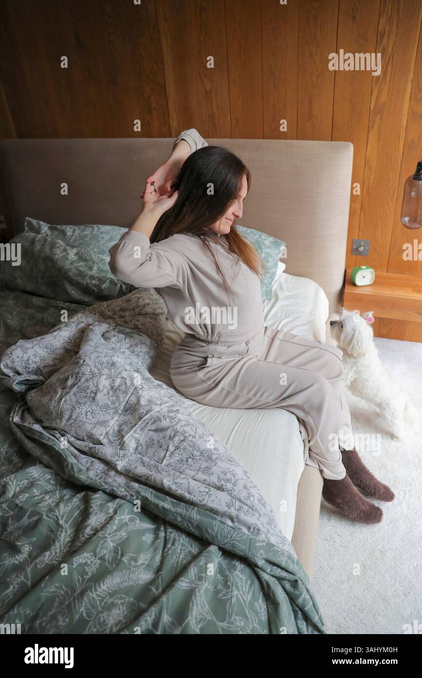 Woman Waking up in bed Banque D'Images