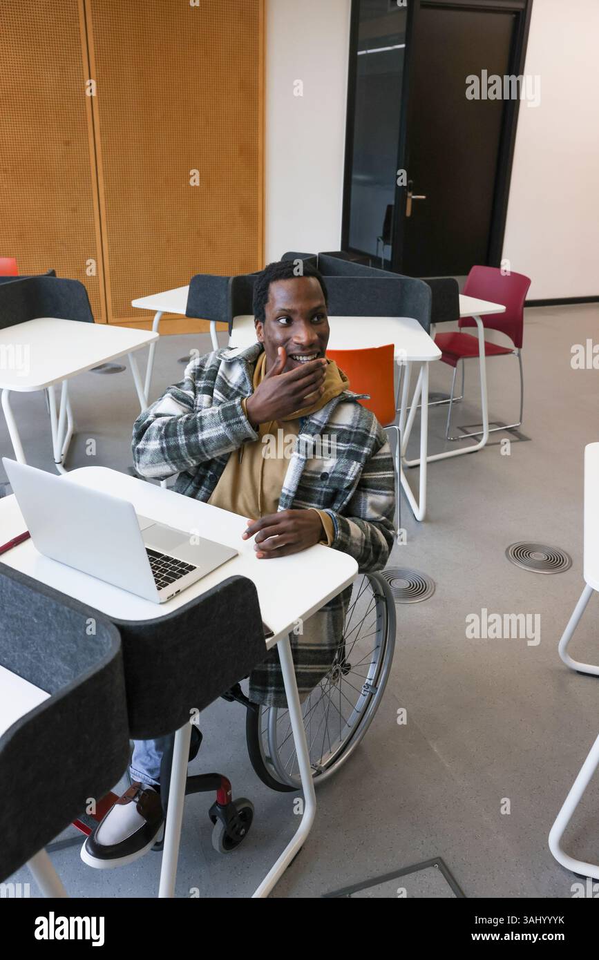 Homme en fauteuil roulant au bureau dans le bureau Banque D'Images