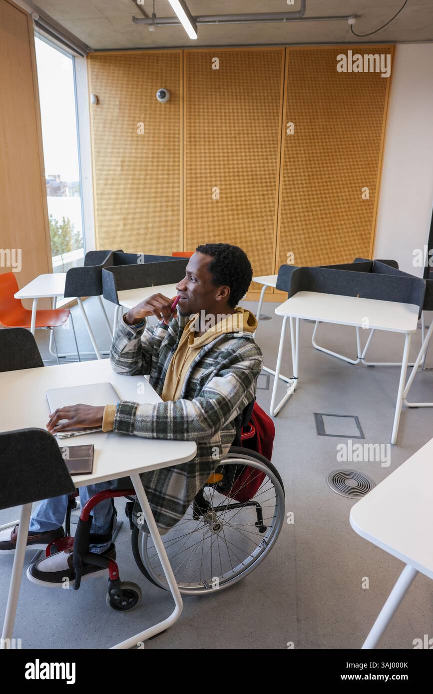 Homme en fauteuil roulant assis dans le bureau Banque D'Images