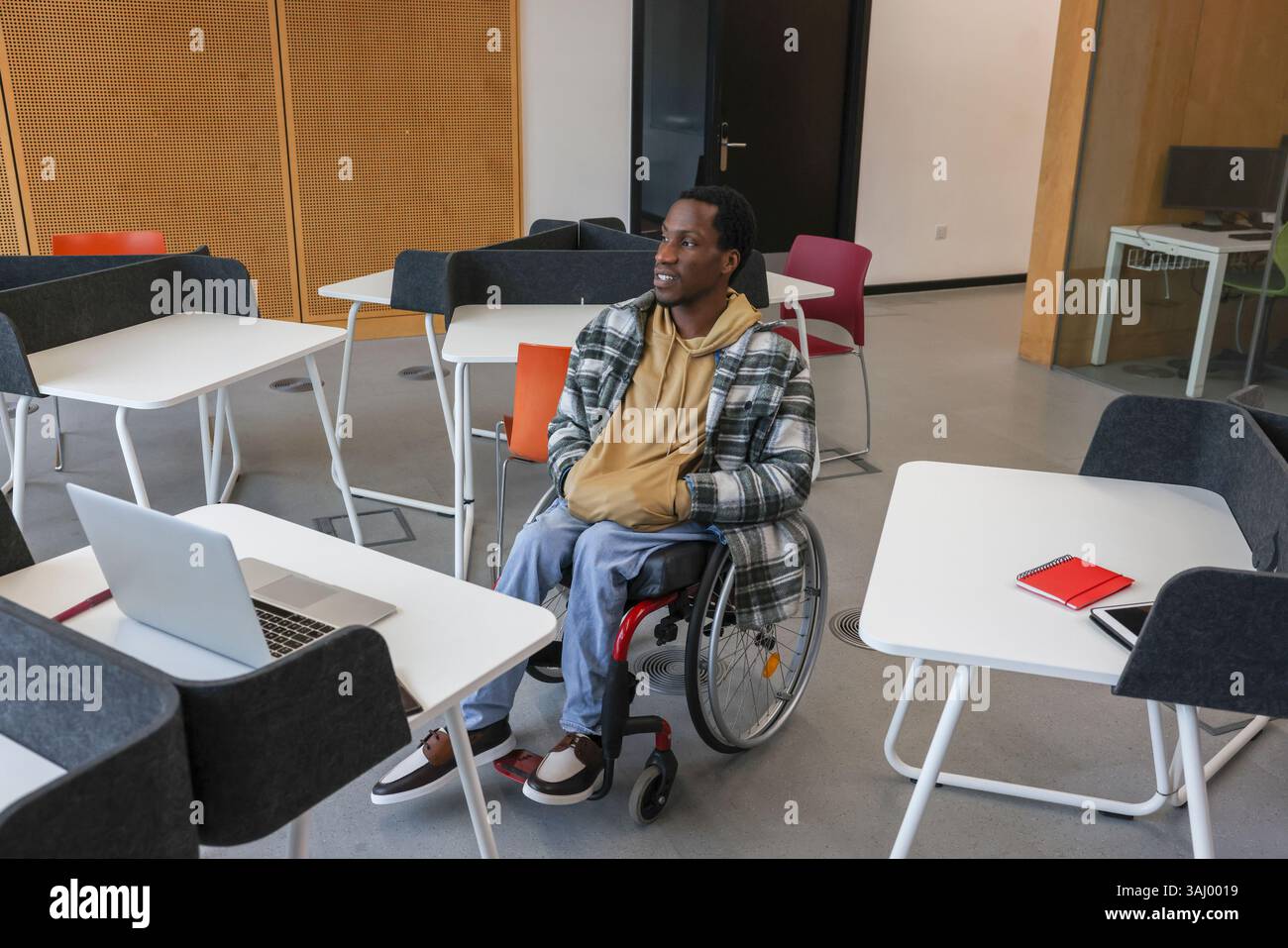 Homme en fauteuil roulant au bureau dans le bureau Banque D'Images