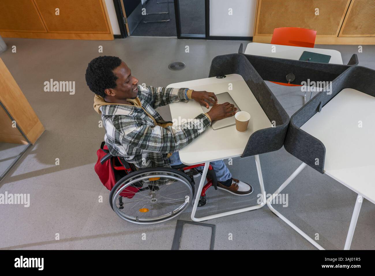 Homme en fauteuil roulant assis dans le bureau Banque D'Images