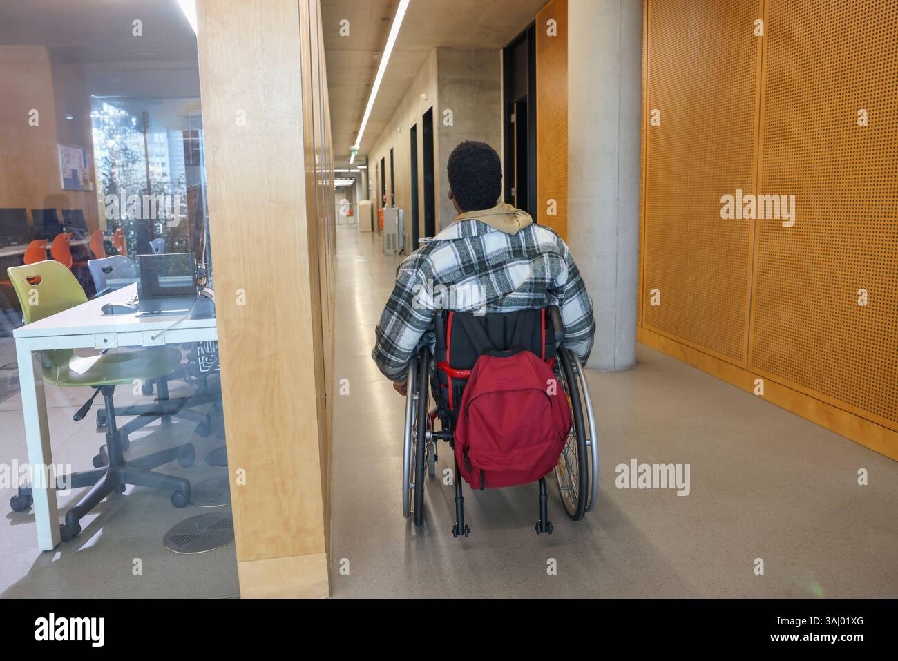Homme en fauteuil roulant dans le couloir du bureau Banque D'Images