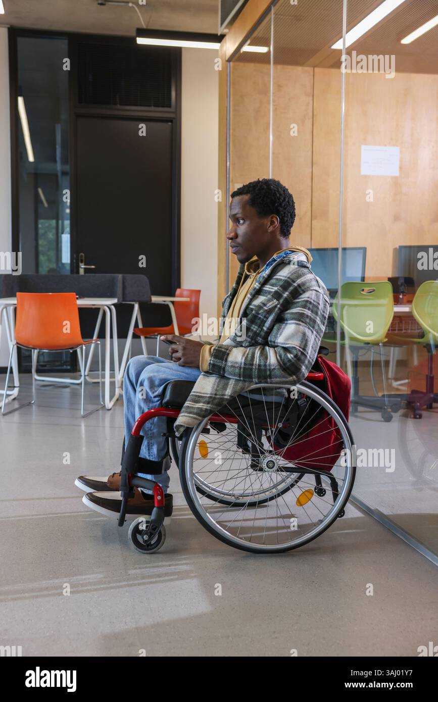 Homme en fauteuil roulant au bureau Banque D'Images