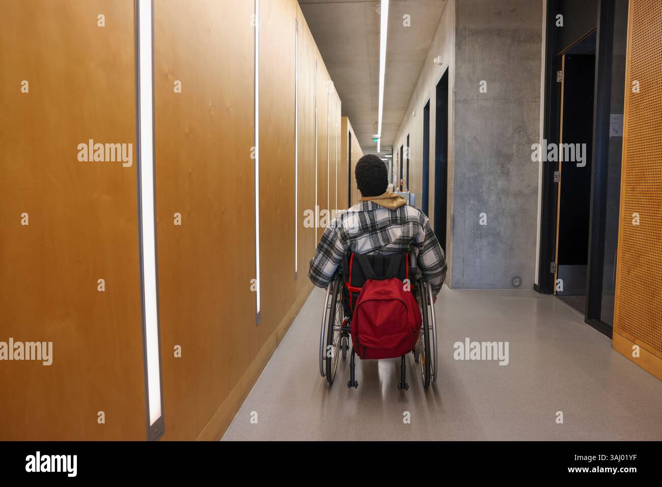 Homme en fauteuil roulant dans le couloir du bureau Banque D'Images