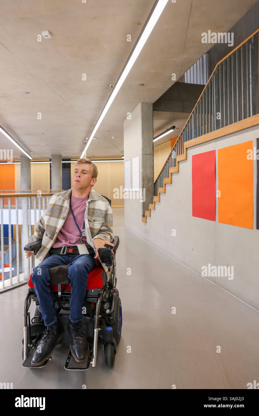 Homme en fauteuil roulant dans le couloir du bureau Banque D'Images