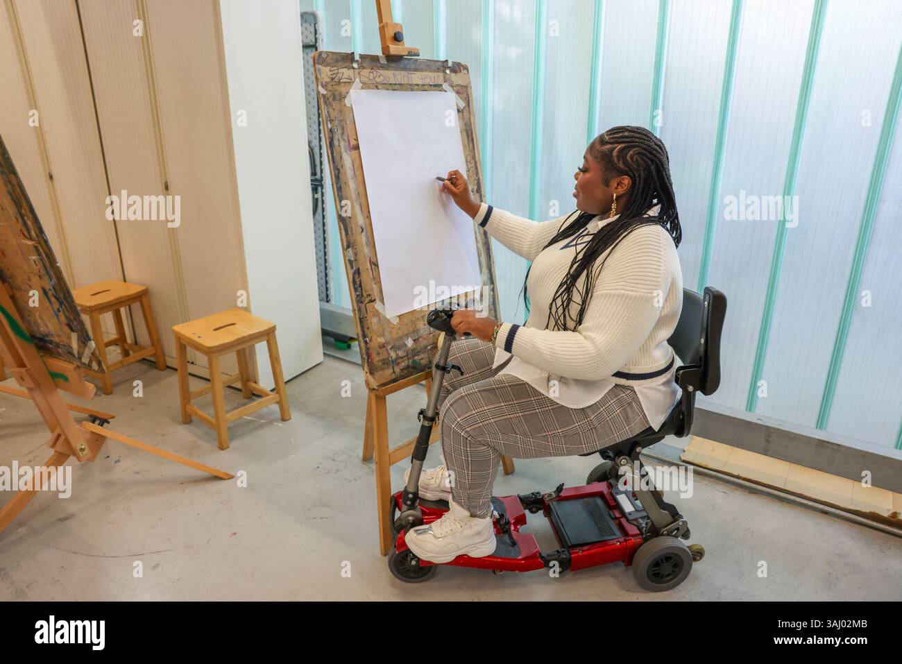Femme handicapée dessinant dans des cours d'art. Banque D'Images
