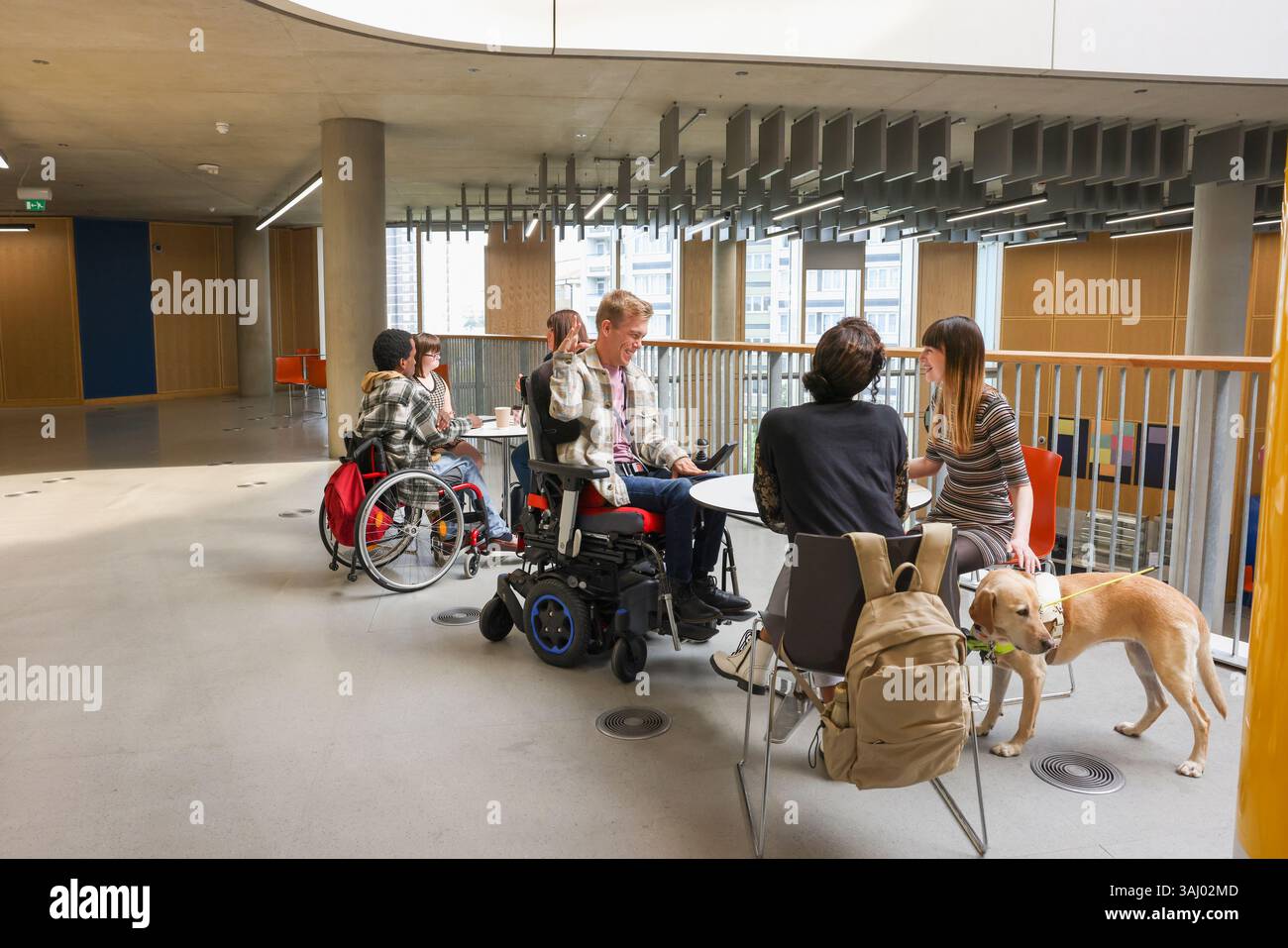 Les personnes ayant divers handicaps aux tables dans le couloir Banque D'Images