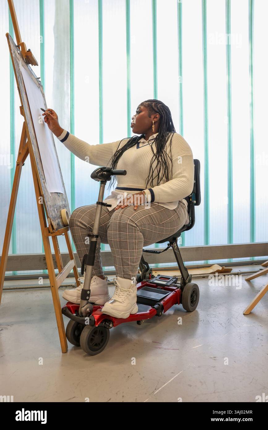 Femme handicapée dessinant dans des cours d'art. Banque D'Images