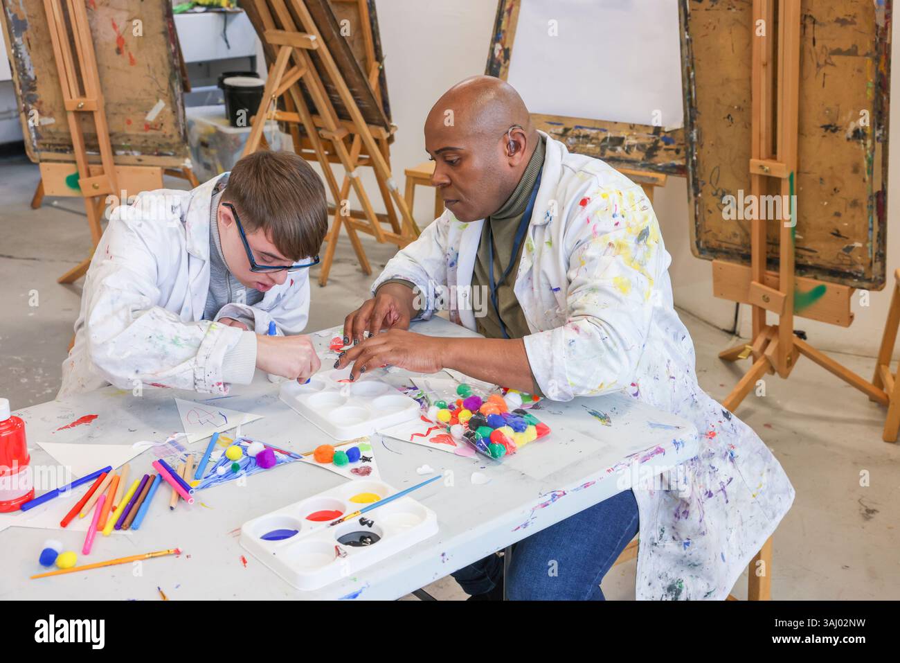 Hommes handicapés peignant en atelier Banque D'Images
