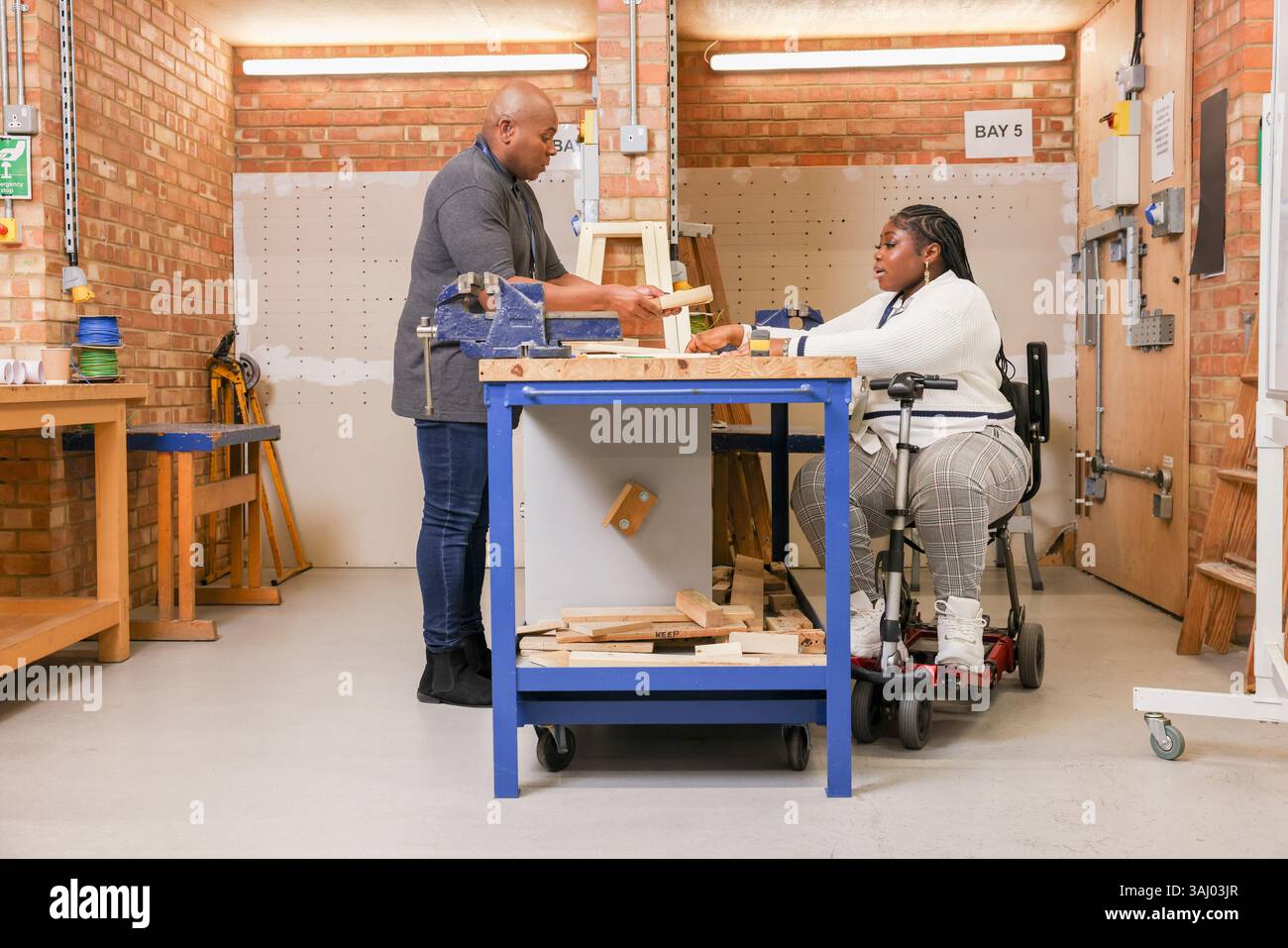 Homme et femme handicapés travaillant en atelier Banque D'Images