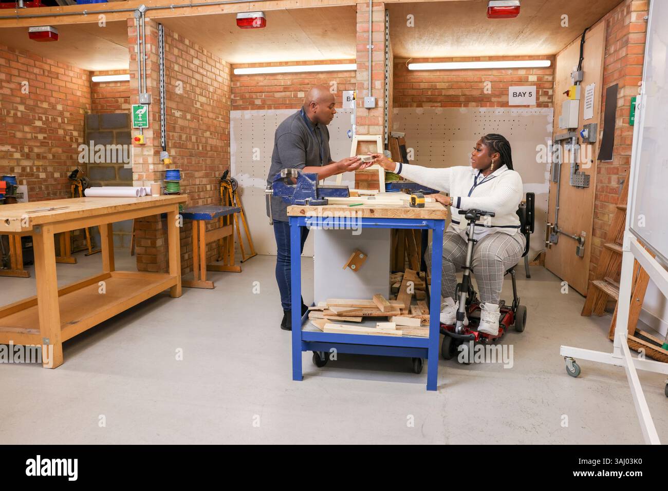 Homme et femme handicapés travaillant en atelier Banque D'Images