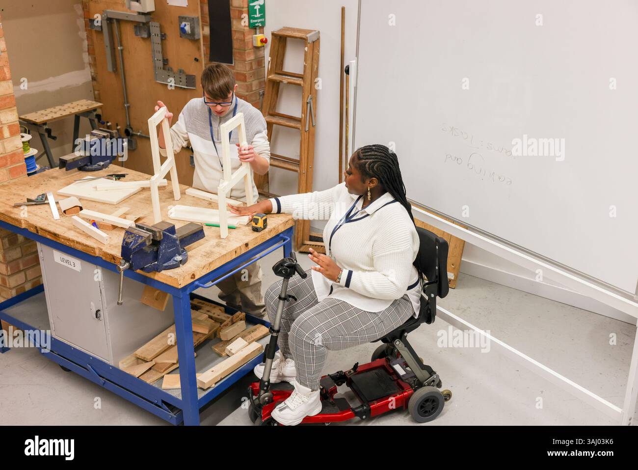 Homme et femme handicapés travaillant en atelier Banque D'Images