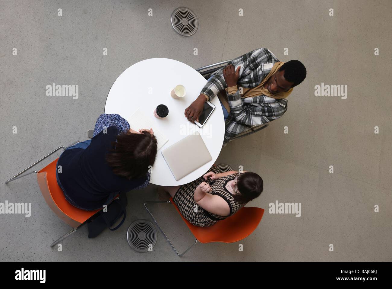 Personnes handicapées assises à table avec ordinateur portable Banque D'Images