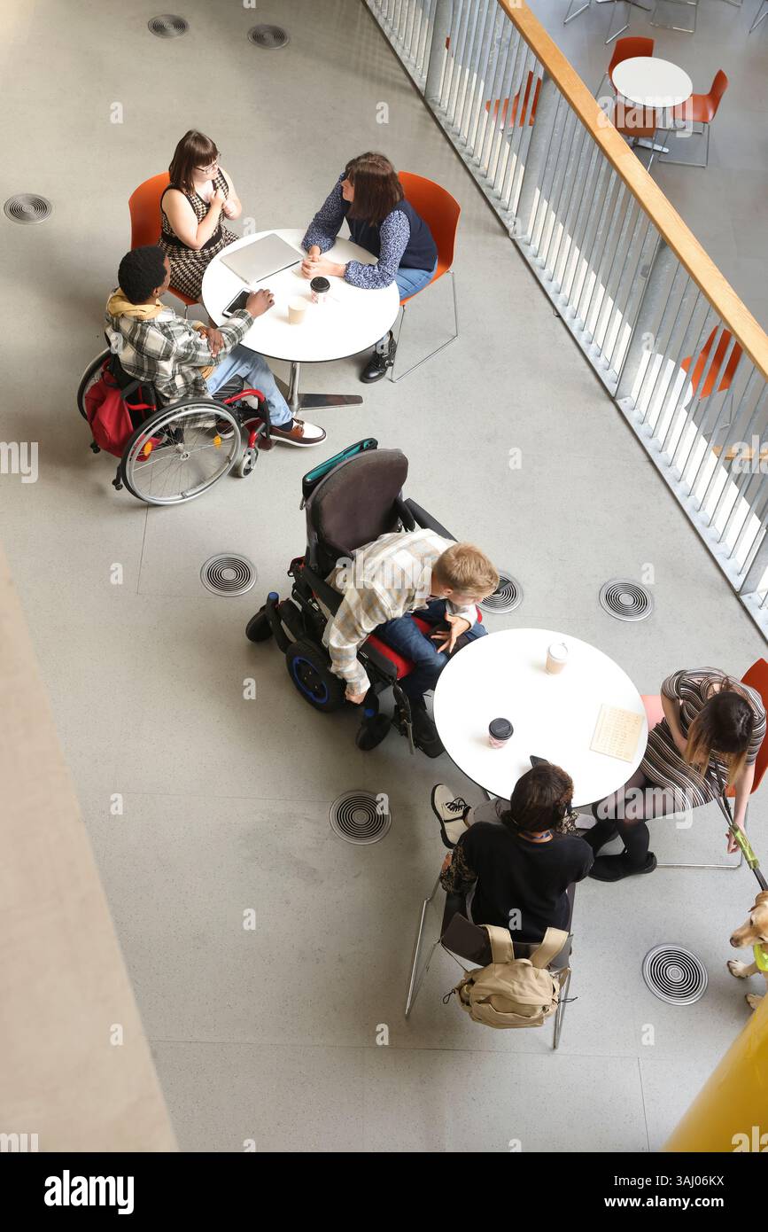 Les personnes handicapées qui parlent à des tables Banque D'Images