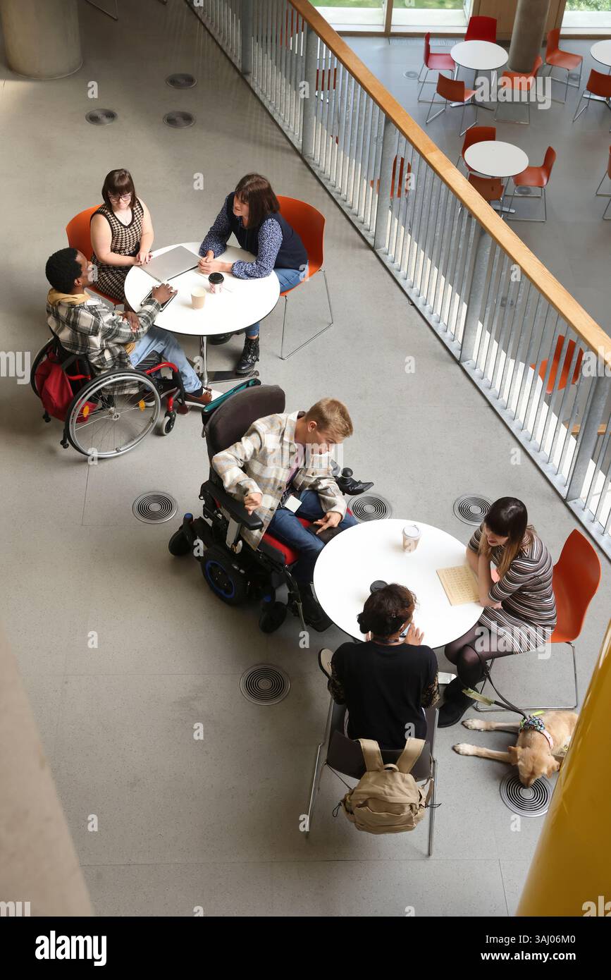 Les personnes handicapées qui parlent à des tables Banque D'Images