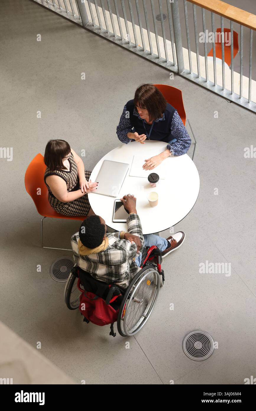 Personnes handicapées parlant à table Banque D'Images