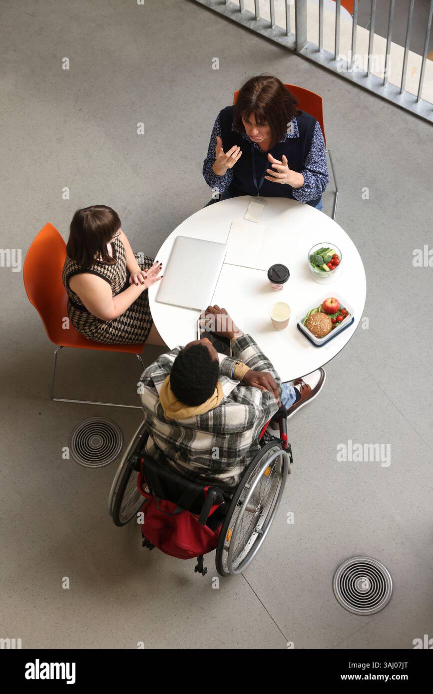 Personnes handicapées parlant à table Banque D'Images