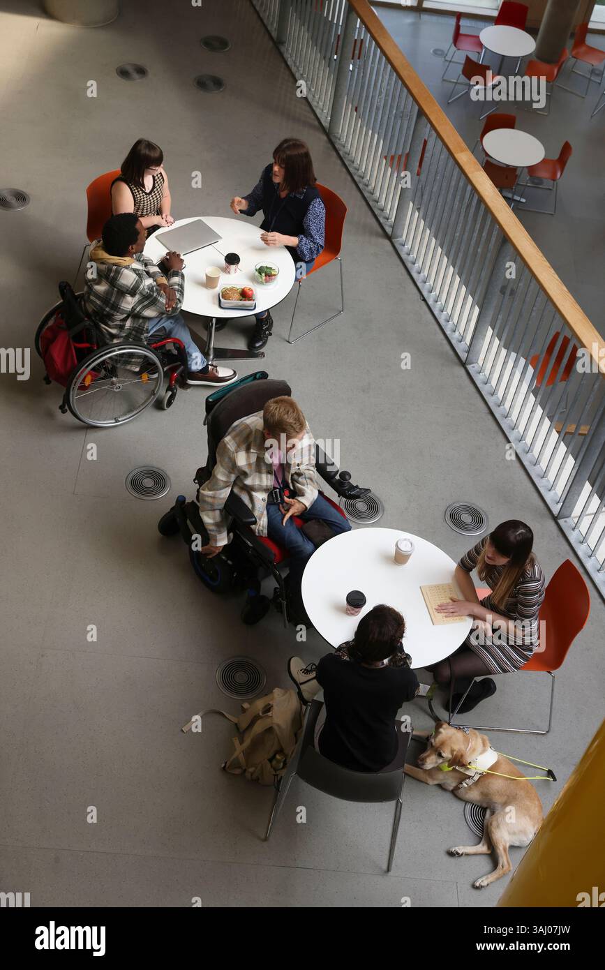 Les personnes handicapées qui parlent à des tables Banque D'Images