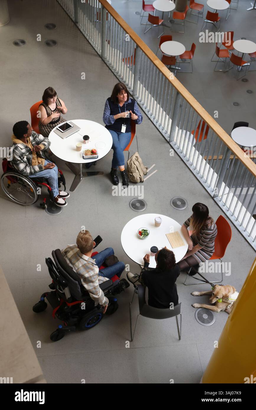 Les personnes handicapées qui parlent à des tables Banque D'Images