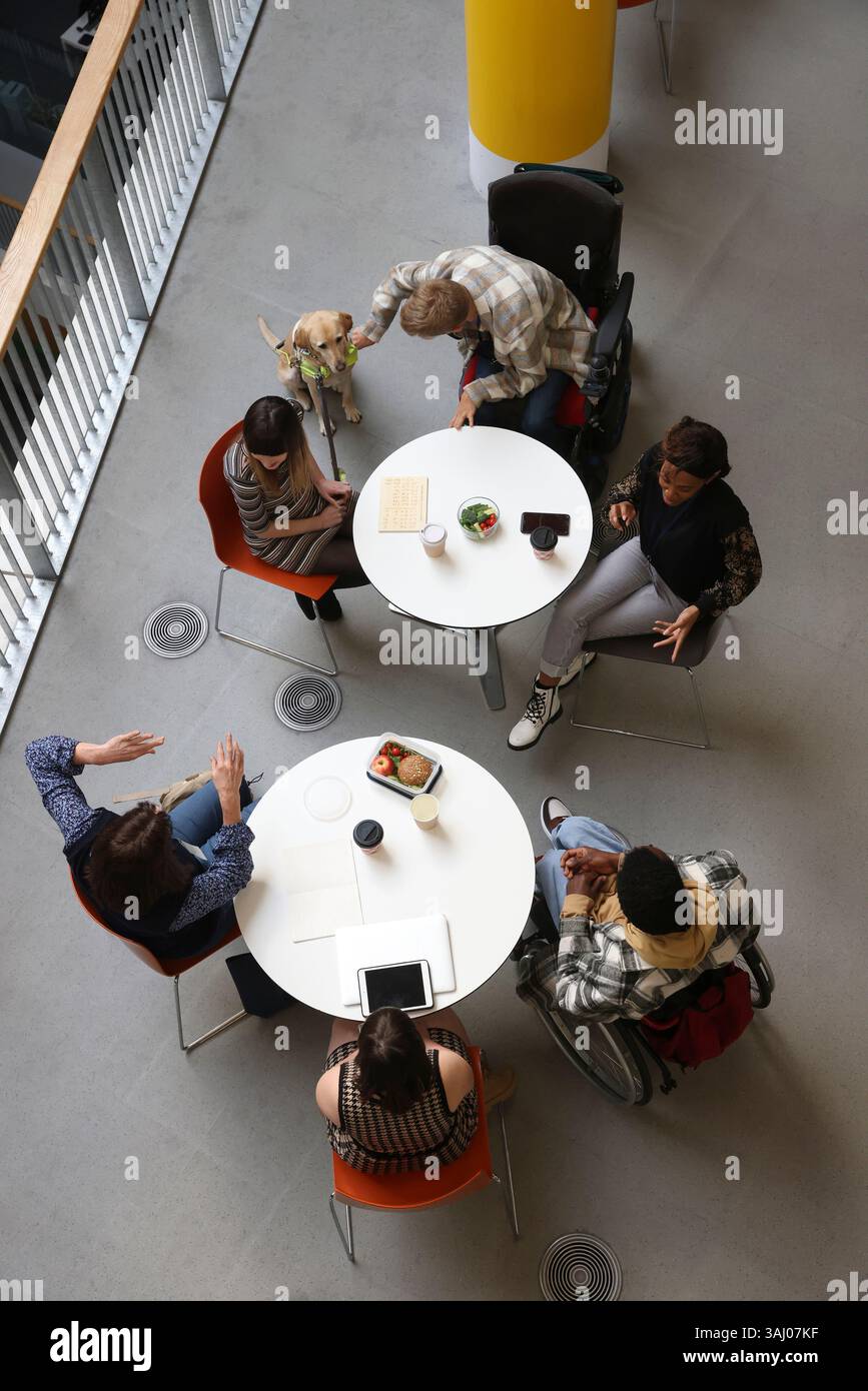 Les personnes handicapées qui parlent à des tables Banque D'Images