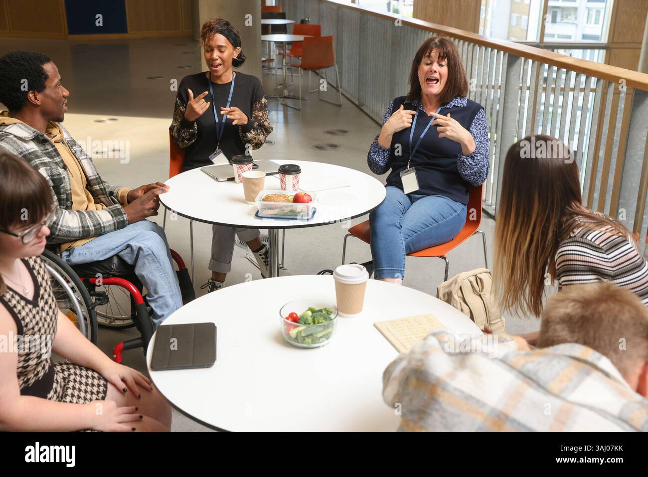 Les personnes handicapées qui parlent à des tables Banque D'Images