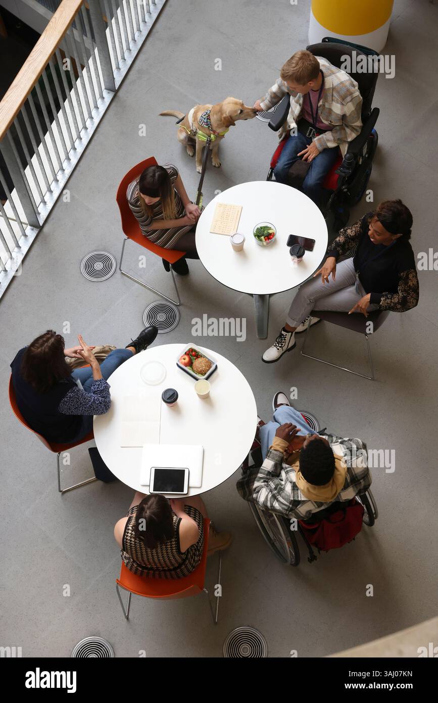 Les personnes handicapées qui parlent à des tables Banque D'Images