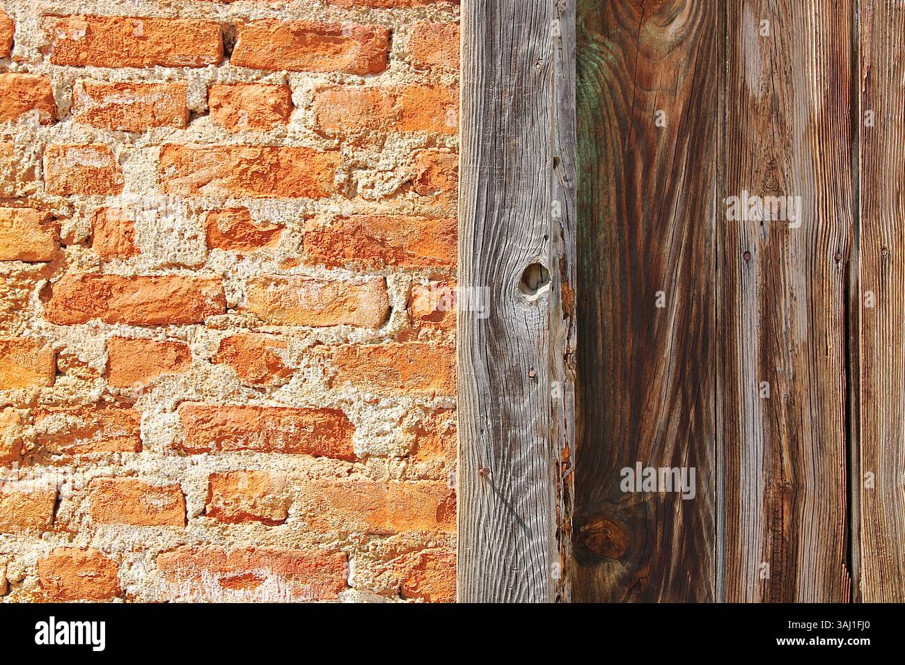 Mur de briques orange avec détail vertical de panneaux en bois, façade rustique d'un bâtiment de campagne vintage. Banque D'Images