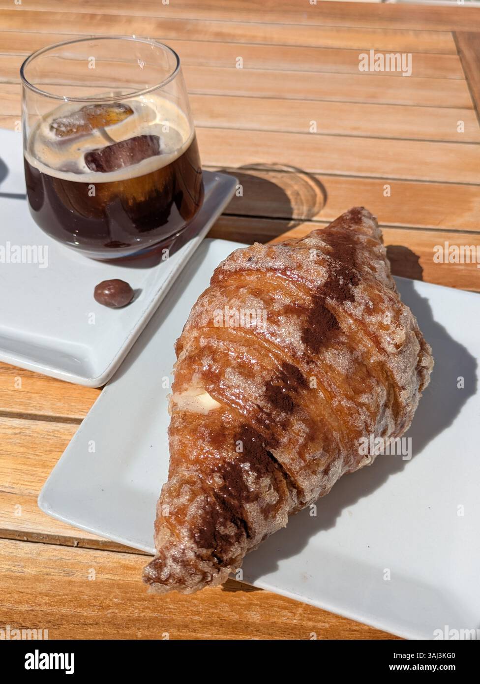 Croissant et café glacé sur table en bois Banque D'Images